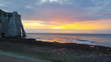 Çarpıcı bir günbatımı, dingin bir okyanus, yüksek uçurumlar ve engebeli bir sahil şeridi boyunca canlı renkler bırakır. Huzurlu sahne doğal güzellik ve sükuneti simgeler, seyahat için ideal ilham veya dekoratif baskılar.