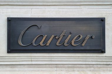 Paris, Polonya, 4 Ağustos 2025: Lüks markalaşmayı ve sofistike mağaza vitrini tasarımını gösteren klasik bir taş duvarda gösterilen zarif karter tabelaları. Metalik işaretler kaliteli işçiliği ve üst düzey estetiği vurguluyor