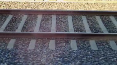 Çakıl taşından bir yatağın üzerine döşenmiş demiryolu rayları temel ulaşım altyapısını gösteriyor. paralel çizgiler ve dokulu yüzey, tren hareketi için gerekli mühendislik kesinliğini vurgular..