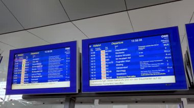 Viyana, Avusturya, 5 Mayıs 2025: Bir tren istasyonundaki dijital kalkış panoları Avrupa 'daki çeşitli tren yolları hakkında ayrıntılı bilgi göstermektedir. ekranlar saatleri, varış noktalarını ve platform bilgilerini, verimli toplu taşımayı gösterir.