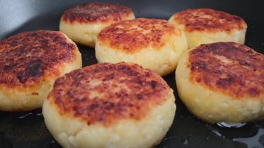 Golden brown potato patties sizzle in a pan, showcasing their crispy exterior and soft interior. ideal for recipe inspiration, these versatile patties make a perfect appetizer, snack, or side dish.