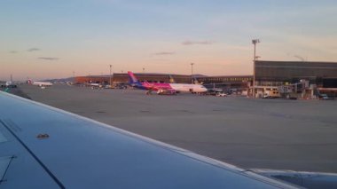 Barcelona, Spain, January 4, 2025: An airplane is stationed at an airport terminal during sunset, with the warm glow of the sky reflecting on the tarmac. the scene captures a bustling travel hub, aviation, transportation, and the anticipation of