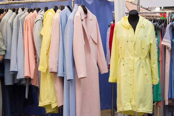 Askıda elbiseler, parlak kadın kıyafetleri. Panayırda elbiseler.