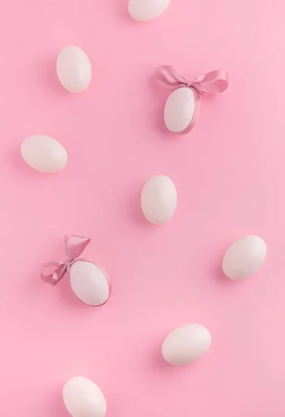 ピンクを基調にした白い卵とサテンリボンがかわいいイースターフラットバック 弓で飾られた卵 ロイヤリティフリーのストック写真