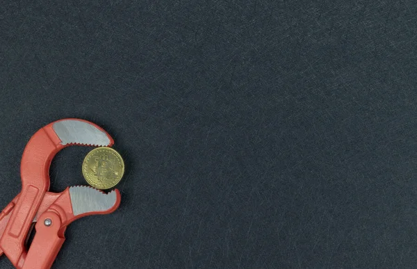 Boru anahtarının ağzında Bitcoin altın. Kripto para birimleri değer kaybediyor. Para birimleri değer kaybediyor. Altın bitcoin enflasyon basıncı. Kavram sembolü. Zorlu ekonomi.