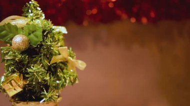 Noel Ağacı dönüşümlü Mutlu Yıllar Güzel Festive fotokopi alanı kartı. Kırmızı arka planda dönen minyatür Noel ağacı. Kırmızı kurdele yanıp sönüyor. Önemli iletileriniz için güzel kopyalama alanı.