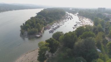 Durgun bir nehir manzarası ve demir atmış tekneler. Ağaçlar günbatımının alacakaranlıklarını yansıtır. Nehrin durgun bir dalında alacakaranlık. Birçok tekne demir aldı, şafak vakti. Sakin bir körfezde hava aracı vuruldu..