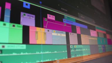 İş yerindeki bilgisayar ekranında imleç video düzenleme programı düzenleyicisini oynayan geniş zaman çizgisi. Video düzenleyici çalışıyor. Ses video düzenleme yazılımındaki bir bilgisayar ekranının Dolly izleme görüntüsü. Alçak alan derinliği.