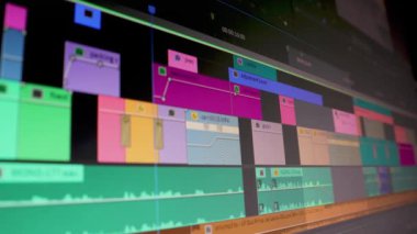 Video düzenleyici çalışıyor. Ses video düzenleme yazılımındaki bir bilgisayar ekranının Dolly izleme görüntüsü. Alçak alan derinliği.