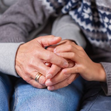 Senior woman and a child holding hands together. Family, help, elderly care and support concept