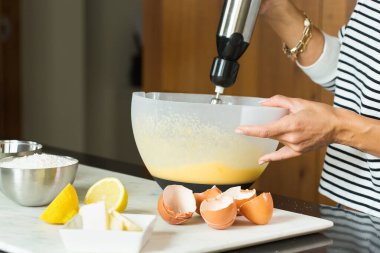 Woman kneading the dough while cooking apple pie in the modern kitchen