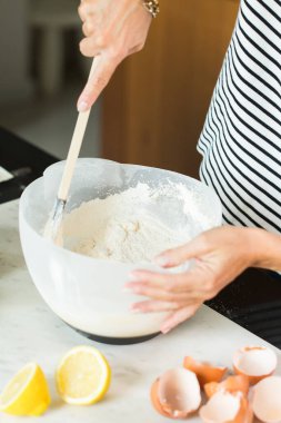 Woman kneading the dough while cooking apple pie in the modern kitchen