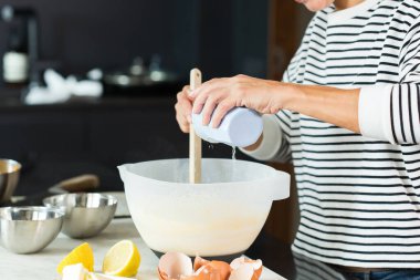 Woman kneading the dough while cooking apple pie in the modern kitchen