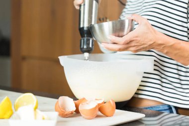 Woman kneading the dough while cooking apple pie in the modern kitchen