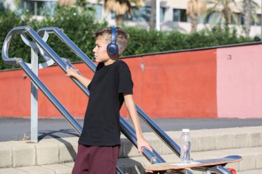 Kaykaylı yakışıklı bir genç açık havada müzik dinliyor. Gençler sokaklarda dolaşıp şehri keşfediyorlar.