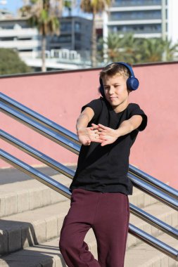 Kaykaylı yakışıklı bir genç açık havada müzik dinliyor. Gençler sokaklarda dolaşıp şehri keşfediyorlar.