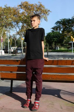 Dışarıda kaykayla duran yakışıklı bir genç. Gençler sokaklarda dolaşıp şehri keşfediyorlar.