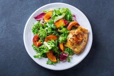 Kızarmış tavuk ve sağlıklı öğle yemeği için taze sebze salatası.