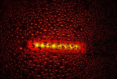 Su yüzeyinde yağ damlaları ve dalgaları olan soyut renkli arkaplan. Yansımalı sıvı damlacıkların makro çekimi. Su damlası desenli renk arkaplanı.