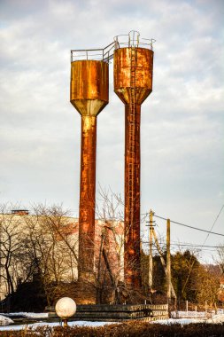 Köylerde kullanılan Rozhnovsky su kulesi ıhlamur koruluğundaki ağaçların arasındaki eski metal su kulesi. .