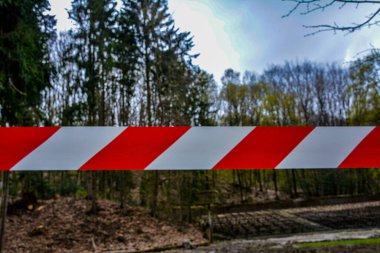 Beyaz ve kırmızı kurdele oyun alanına girmenizi yasaklıyor. Bariyer şeridinin kırmızı ve beyaz uyarı çizgileri geçişi yasaklıyor. Trafiği engelleyen bariyer.