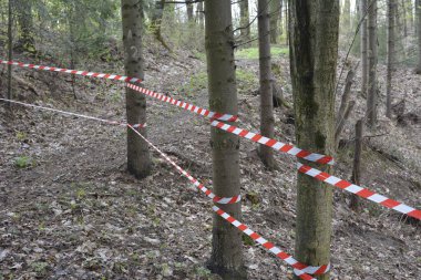 Beyaz ve kırmızı kurdele oyun alanına girmenizi yasaklıyor. Bariyer şeridinin kırmızı ve beyaz uyarı çizgileri geçişi yasaklıyor. Trafiği engelleyen bariyer.