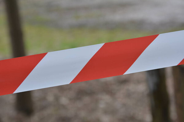 Белая и красная лента запрещает вход в Playground.Red и белые линии предупреждения барьерной ленты запрещают проход. Барьер, который запрещает движение.