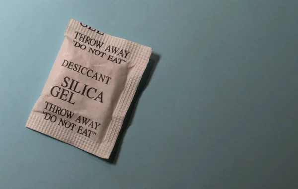 Desiccant or silica gel in white paper packaging.Packet of silica gel desiccant for electronic device protection .