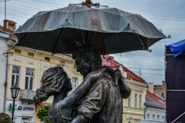 Drohobych, UKRAINE.Kasım 2022: Aşıklar Anıtı. Aşıklar yağmurdan bir şemsiye altında saklandılar.