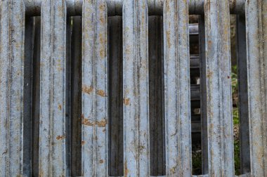 Paslı eski bir Sovyet radyatör bataryası. Demir radyatörler, kümelenmiş eski ısıtma elementleri. Yerde yatan dökme demirden yapılmış eski bataryalar..