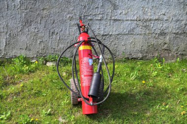 Lviv, Ukrayna. 10 Ekim 2023. Büyük kırmızı yangın söndürücü siyah bir hortumla tekerleklerde. Tekerlekli büyük mobil yangın söndürücü. .