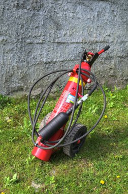 Lviv, Ukrayna. 10 Ekim 2023. Büyük kırmızı yangın söndürücü siyah bir hortumla tekerleklerde. Tekerlekli büyük mobil yangın söndürücü. .