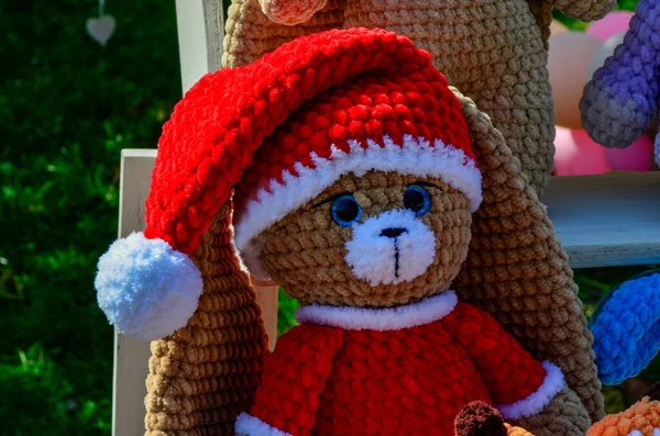 Knitted bear toy on Christmas background with space for copy.Christmas winter card with teddy bear .