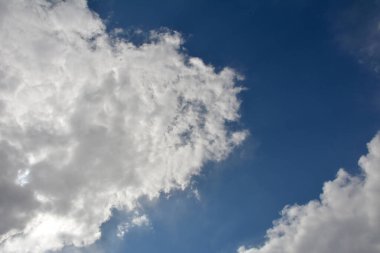 Mavi gökyüzü arkaplanlı beyaz bulut. Bulutlu açık mavi gökyüzü. Beyaz kabarık bulutlar üzerinde görülebilir.