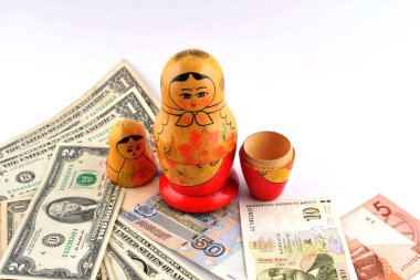 İçinde dolar olan Rus bebeği beyaz arka planda izole edilmiş. Matrioshka bebekleri renkli domuzcuk demeti dolusu para..