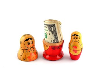 İçinde dolar olan Rus bebeği beyaz arka planda izole edilmiş. Matrioshka bebekleri renkli domuzcuk demeti dolusu para..