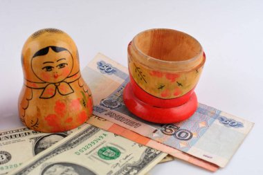 İçinde dolar olan Rus bebeği beyaz arka planda izole edilmiş. Matrioshka bebekleri renkli domuzcuk demeti dolusu para..