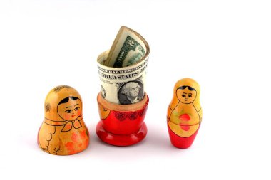 İçinde dolar olan Rus bebeği beyaz arka planda izole edilmiş. Matrioshka bebekleri renkli domuzcuk demeti dolusu para..