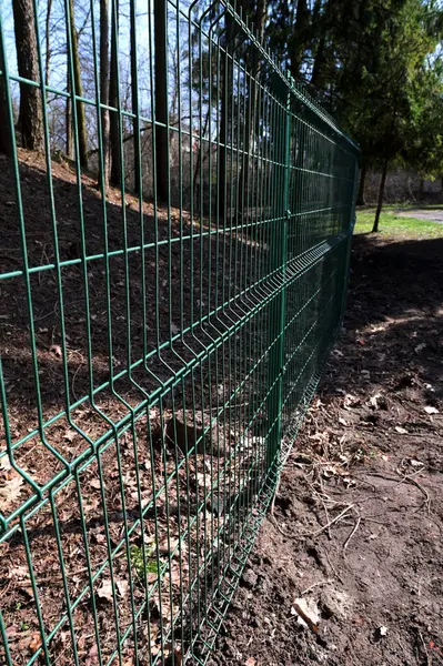 Modern metal fence for fencing the yard area. Horizontal sections of the fence made of metal.Steel grating fence.
