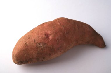 Sebzeler: Beyaz arka planda tatlı patates. Taze tatlı patates. Tatlı patates yemek yüksek kolesterolü engelleyebilir..