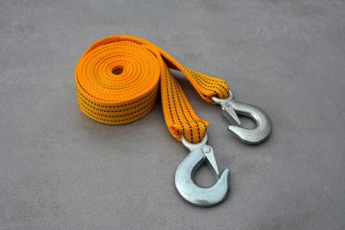 Çelik kancalı çekici, gri arka planda, üst manzaralı. Araç güvenli. Kancalı sarı ya da turuncu renkli halat çekin.