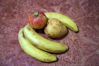 Güneş ışığında bir demet taze muz. Tahta bir masanın üzerinde sarı muz demeti. Dilimlenmiş muzla birlikte lezzetli görünüyor..
