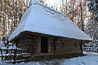 Karpatya karlı ormanlarında geleneksel bir ahşap ev. Tatil köyünde av kulübesi. Kış doğasının güzelliği..