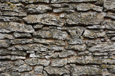 Çekici kahverengi doğal kireç taşı bloğunun tam çerçeve arkaplanı küller desenli, engebeli desen taş bloklar ve tam güneş ışığı ile fotokopi alanı.