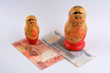 Rus Rublesi (RU) para birimi banknotu ve Rus oyuncak bebekleri ile turizm konsepti ticari ekonomik konu olarak ele alınır