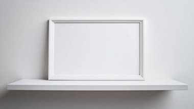 Bu minimalist görüntü düz bir duvara karşı parlak bir rafta boş beyaz bir çerçeve içeriyor, yaratıcılığı ve modern dekorasyon stillerini sergilemek için mükemmel..