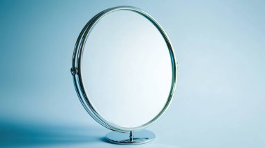 Parlak gümüş çerçeveli parlak, gösterişli bir ayna. Lüks dekorasyon ve güzellik ortamları için idealdir. Bu resim zarafeti basitçe yakalar..