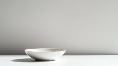 Basit bir masaya yerleştirilmiş minimalist beyaz bir kâse, tarafsız bir arkaplana karşı temiz ve zarif bir tasarımı vurguluyor. Modern dekorasyon için mükemmel..