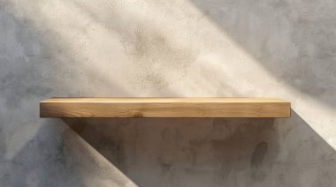 Minimalist ahşap bir raf, desenli beton bir duvara karşı sunulur. Işık ve gölgenin etkileşimi, dekorasyon için ideal, davetkar bir atmosfer yaratır..