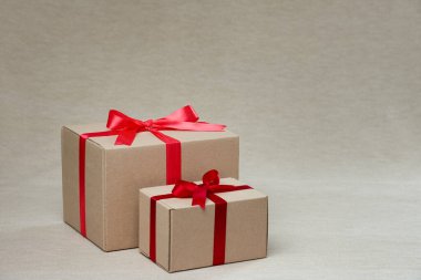Fotokopi alanı olan kırmızı kurdeleli iki hediye kutusu. Stüdyo görüntüsü yüksek açılı..